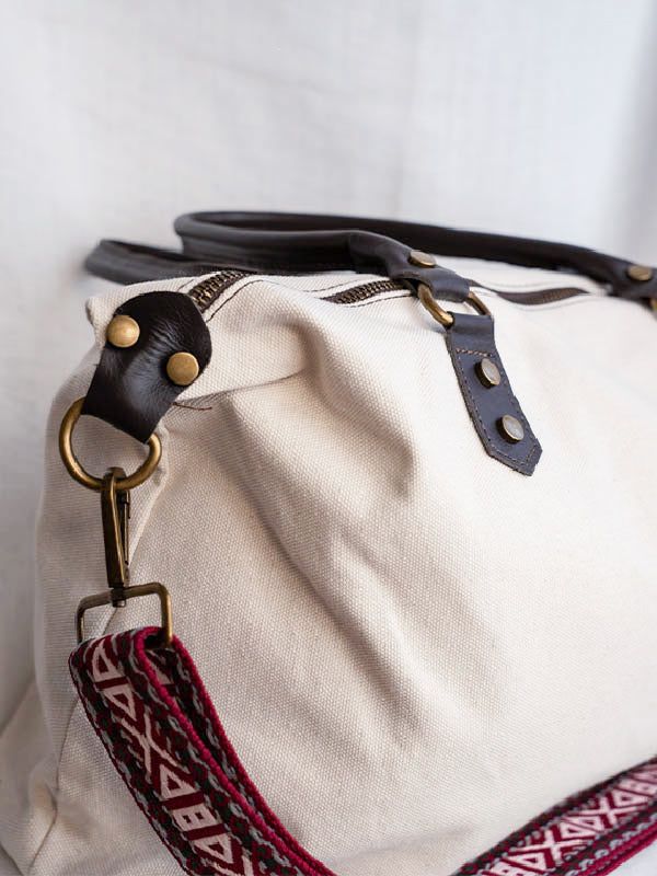 Detalle de la cremallera del bolso shopper color blanco crudo con correa estampada