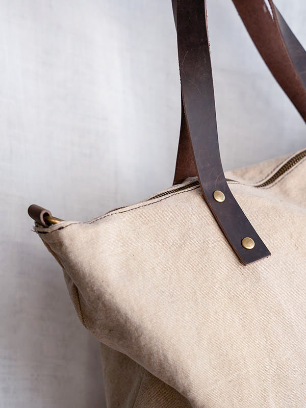 Detalle del asa del bolso shopper de color beige