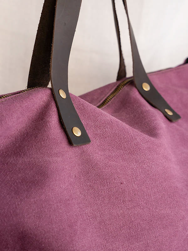 Detalle del asa del bolso shopper de color berenjena