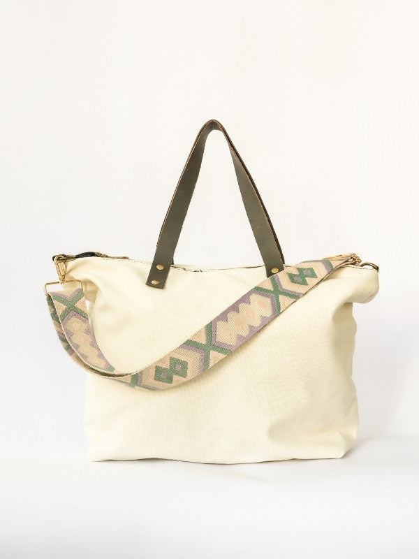 Bolso de loneta color blanco crudo con correa.