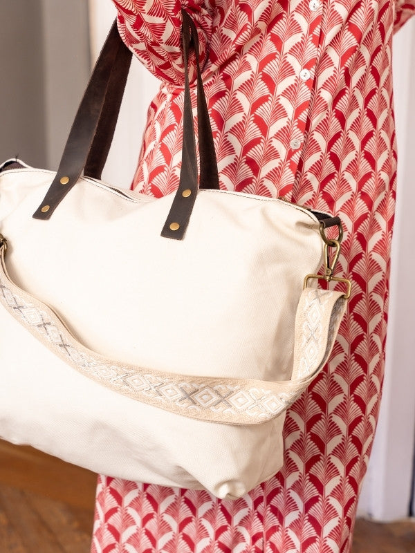 Bolso de loneta color blanco crudo con correa.